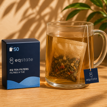 EQ Tea Filters box of 50 beside a glass mug with a filled paper filter and EQ tag