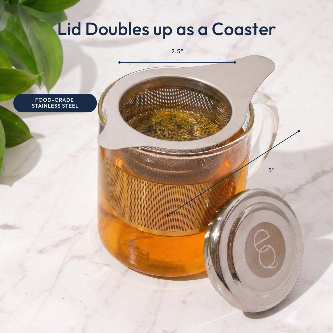 A clear glass tea cup with amber tea, a stainless steel mesh infuser, and a matching lid placed beside it on a white marble surface. Text overlays read 'Lid Doubles up as a Coaster' with dimension markings.